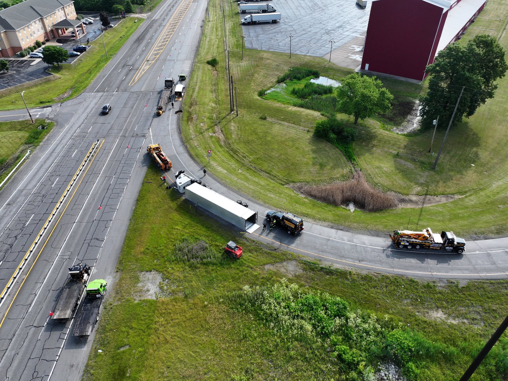 Wide aerial view of trailer recovery near a roadway