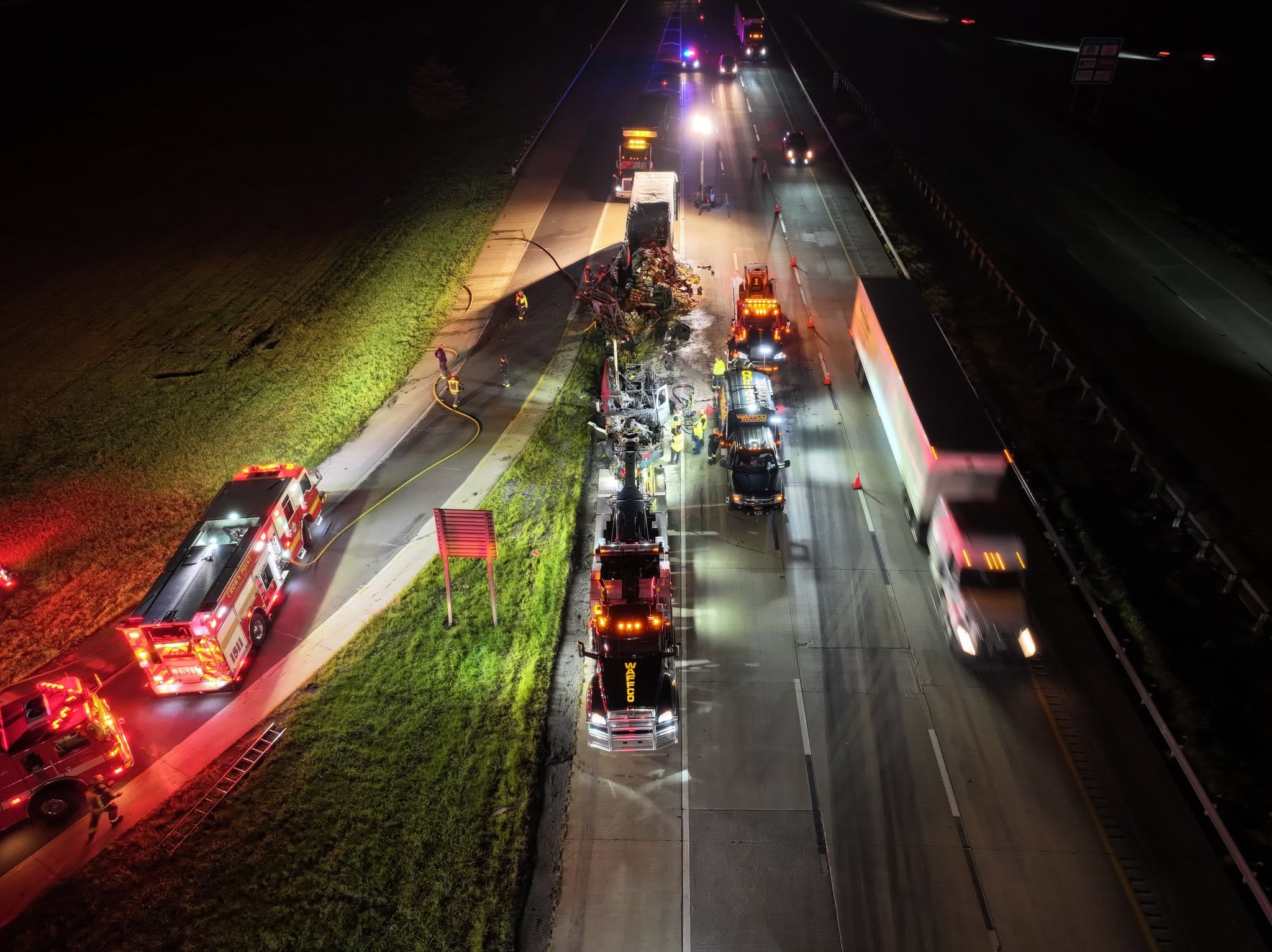 Night crash scene with recovery trucks and emergency lighting