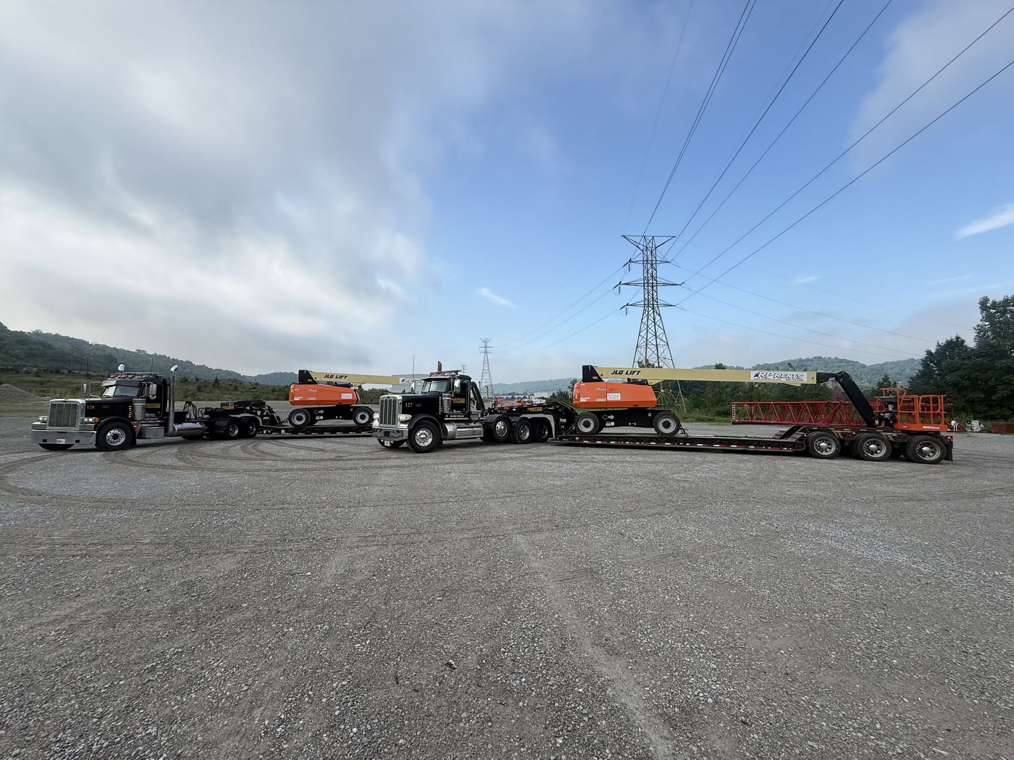 Waffco hauling lift equipment on lowboy trailers
